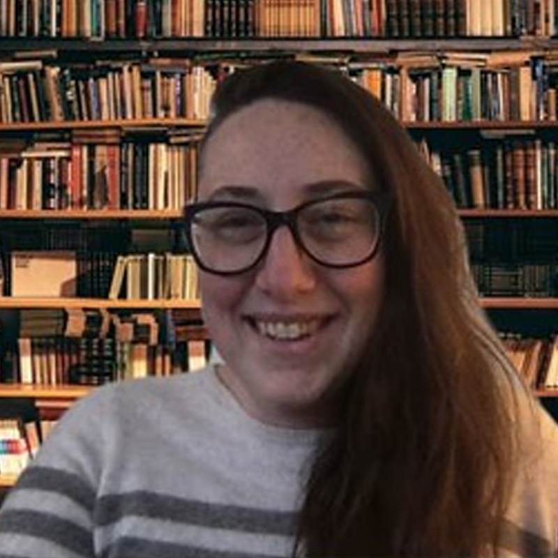 Screenshot of an instructor, in front of bookshelves, recording a video message.